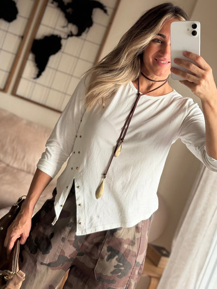 Camiseta Kira blanca asimétrica con tachuelas y pantalón de camuflaje