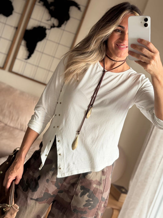 Camiseta Kira blanca asimétrica con tachuelas y pantalón de camuflaje