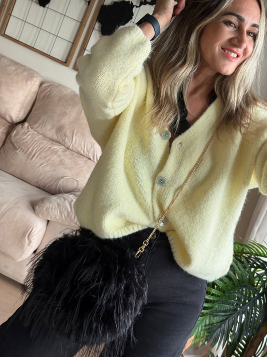 Detalle del punto suave de la chaqueta Vainilla con bolso de plumas negro