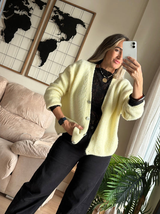 Chaqueta de punto vainilla abierta sobre camiseta negra